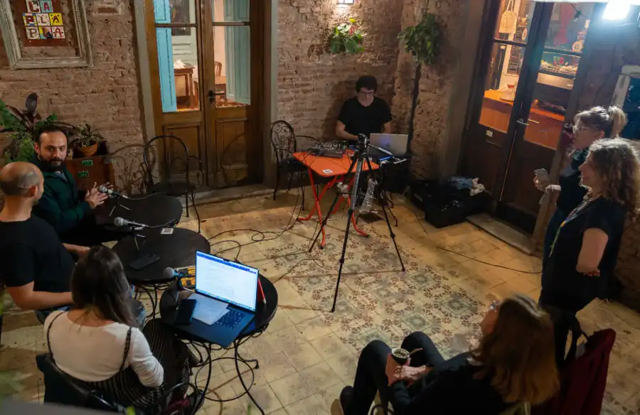 Participantes de Radio La PlaPla alrededor de micrófonos y equipos